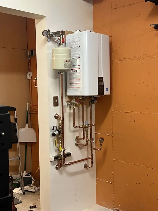 Plumbing technician inspecting water heater connections in Bandon